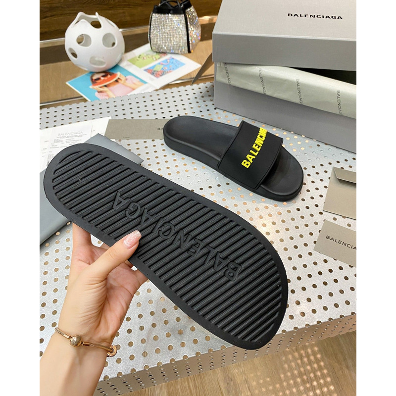 Ba*len*cia*ga pool slide sandal in black rubber with yellow 3d Ba*len*cia*ga logo